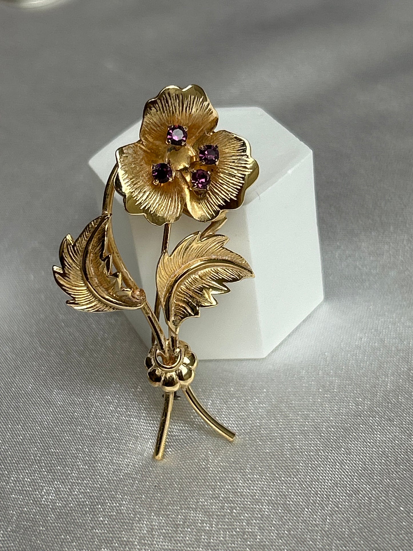 Broche doré en plaqué or modèle fleur et strass violets